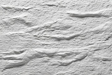 Poster - A close-up shot of a white textured stone wall, showcasing its rough surface and irregular pattern, ideal for backgrounds and creative designs, with natural stone effect.