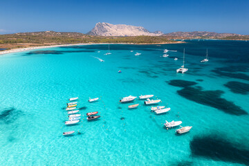 Wall Mural - aerial view of luxury yachts and boats on blue sea, beautiful island on summer sunny day. sandy beac