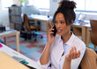 © Wavebreak Media - Businesswoman using smartphone and gesturing at desk in office, with keyboard, papers, copy space