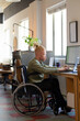 © Wavebreak Media - African American man typing at desk from wheelchair in modern office, using laptop and monitor