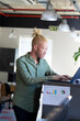 © Wavebreak Media - African American man typing at standing desk in modern office, with laptop and sales-tracker chart