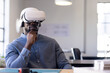 © Wavebreak Media - African American man sitting at desk in studio, with VR headset, cutting mat and model pieces