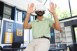 © Wavebreak Media - Young Asian Indian man sitting on table using VR headset in modern classroom, with laptop