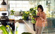 © Wavebreak Media - Young Asian Korean woman using tablet by glass partition with notes in open-plan office, copy space