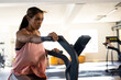 © Wavebreak Media - Young woman using stationary cardio machine with digital display in modern gym, with bright windows