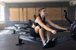 © Wavebreak Media - Woman rowing on indoor rowing machine in spacious gym, with kettlebells and natural light