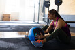 © Wavebreak Media - Woman performing core exercise on gym floor in gym studio with medicine ball, copy space