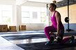 © Wavebreak Media - Mid-adult female lunging holding kettlebells in gym with plyo boxes and squat rack, copy space
