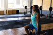 © Wavebreak Media - Woman lifting black kettlebells with yellow handles in gym training area, copy space