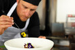 © Wavebreak Media - Mid-adult male chef placing yellow flower on dish using tweezers in restaurant kitchen, copy space