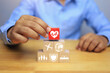 © AREE - life insurance concept with businessman arrange red dice heart icon placed on top of stack representing types of life insurance such as heart disease, accident, travel and family benefit