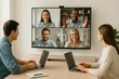 © Katyam1983 - Remote team meeting on large screen in clean workspace
