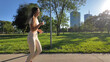 © astrosystem - Young woman running and jogging in urban park.