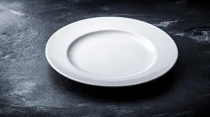 Poster - White plate sits on a black countertop. The plate is empty and has a clean, minimalist appearance. The contrast between the white plate and the dark countertop creates a sense of simplicity