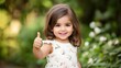 © Adam - Adorable Toddler Girl Giving Thumbs Up in Garden
