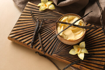 Wall Mural - composition with bowl of tasty pudding, vanilla sticks and wooden board on color background