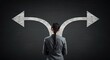 © Stocksy - Woman facing two diverging arrows representing choice or decision on dark background.