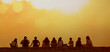 © Maxim Chuev - Young teenage people - guys and girls - sit on castle wall watch the sunset. Group of nine 9 happy people sits on background of empty sunset beach. Travel vacations Back rear view. Kalemegdan fortress