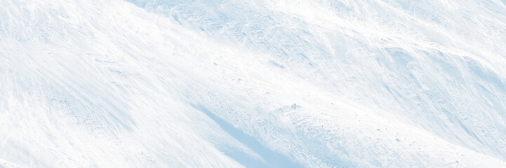 Wall Mural - wide panoramic winter background with snowy ground. natural snow texture. wind sculpted patterns on 