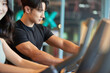 © Dialogue Frame - Young Asian Man and Woman Exercising Together at Gym