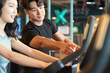 © Dialogue Frame - Young Asian Man and Woman Exercising Together at Gym