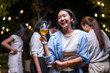 © Wasana - A woman is holding a glass of beer and smiling