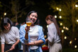 © Wasana - A woman is holding a glass of beer and smiling