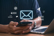 © IDOL'foto - Digital marketer using email marketing tools on laptop and smartphone, sending newsletters and analyzing campaign performance to engage subscribers and grow business through personalized content
