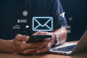 digital marketer using email marketing tools on laptop and smartphone, sending newsletters and analy