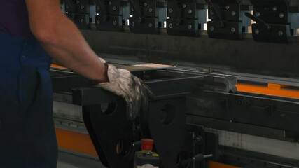 Fototapete - In a bright workshop, a skilled operator uses a bending machine to shape a sheet metal part. Focused on the task, hands maneuver the machine for perfect precision in production.