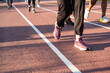 © InveStock - A group of people engage in a physical activity on a sunny day at a track event.