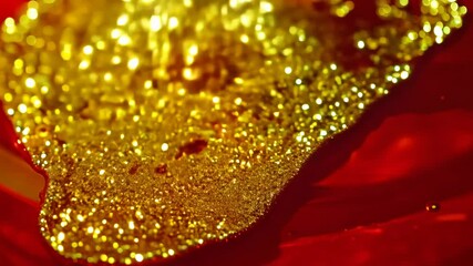 Poster - Dynamic drops of yellow glitter in red oil or ink diffusing through liquid, creating an abstract syrup swirls