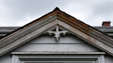 Victorian era gable detail in wood with faded paint showcases intricate craftsmanship and historical charm