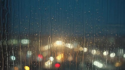 Aufkleber - Light rain on a windowpane with blurred city lights.

