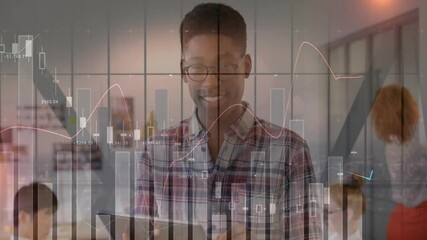 Poster - man standing smiling in open-plan finance office, showing candlestick charts overlaying laptops