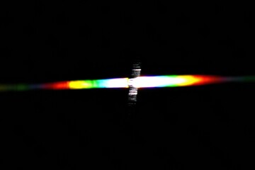 Poster - A vibrant spectrum of colors emerges from a dark background, creating an intriguing visual effect reminiscent of light diffraction.