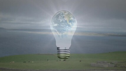Poster - Floating surreal light bulb with Earth globe hovering above coastal pasture grazing cows roaming