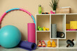 © New Africa - Different fitness equipment and sneakers near beige wall indoors