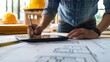 © Fidel - Architect Working on Blueprints with Digital Tablet