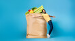 © Prostock-studio - A man in casual attire appears delighted while holding a large paper bag filled with fresh groceries. He stands against a blue backdrop, showcasing the joy of shopping in today's world.