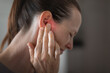 © kieferpix - Young woman suffering from ear pain and tinnitus. Cause of earache includes otitis, earwax buildup.