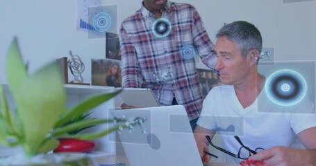 Poster - Colleagues studying business data on laptop in modern office, with holographic charts and plant