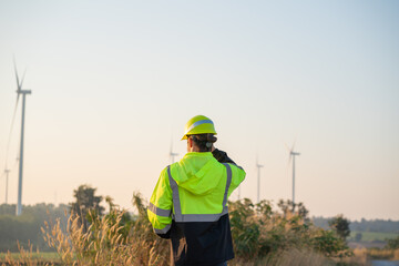 Wall Mural - engineer wearing uniform inspection and survey work in wind turbine farms rotation to generate elect
