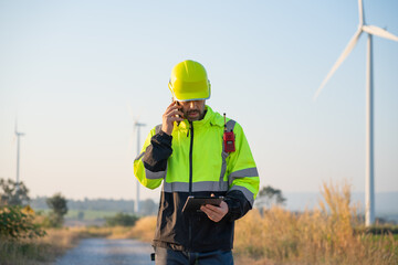 Wall Mural - engineer wearing uniform inspection and survey work in wind turbine farms rotation to generate elect
