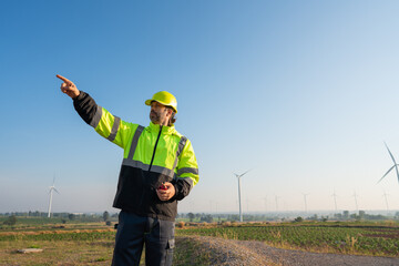 Wall Mural - engineer wearing uniform inspection and survey work in wind turbine farms rotation to generate elect