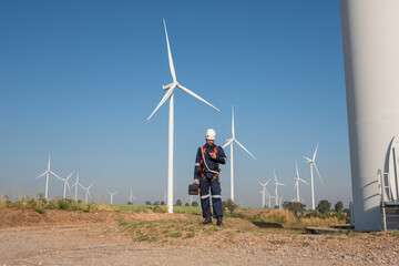Wall Mural - engineer wearing uniform inspection and survey work in wind turbine farms rotation to generate elect