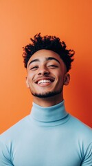 Poster - Young man smiling cheerfully against an orange background, wearing a blue turtleneck, showcasing confidence and positive emotions