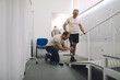 © yossarian6 - Rehabilitation specialist assists an individual with limb loss in adjusting their new prosthesis
