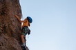 © zhukovvvlad - climber boy. the child trains in rock climbing. cute teen kid climbing on rock with insurance, lifestyle sport people concept.