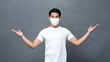 © Atstock Productions - Young Asian man wearing face mask with opening arms, carefree gesture, on isolated gray background studio shot
